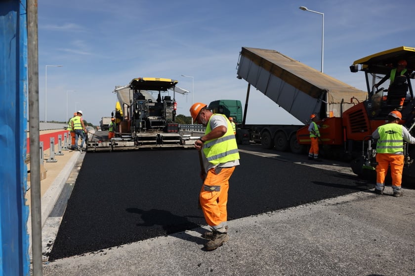 Robotnicy pracujący na wiadukcie, układają ostatnią warstwę nawierzchni