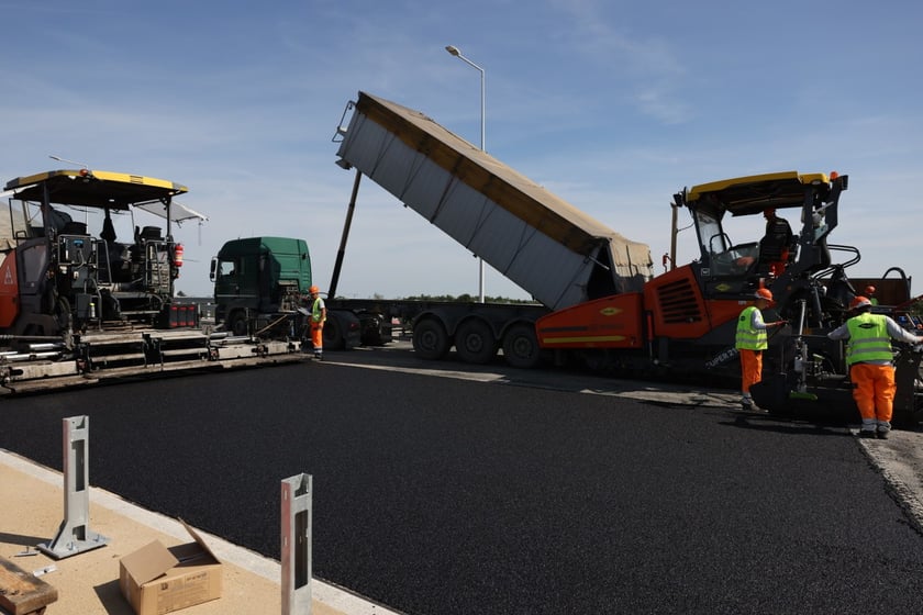 Robotnicy pracujący na wiadukcie, układają ostatnią warstwę nawierzchni