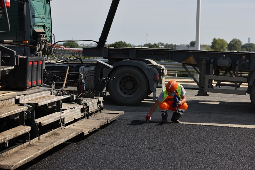 Robotnicy pracujący na wiadukcie, układają ostatnią warstwę nawierzchni