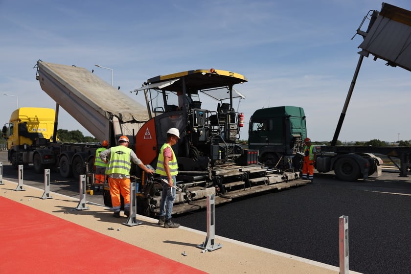 Robotnicy pracujący na wiadukcie, układają ostatnią warstwę nawierzchni