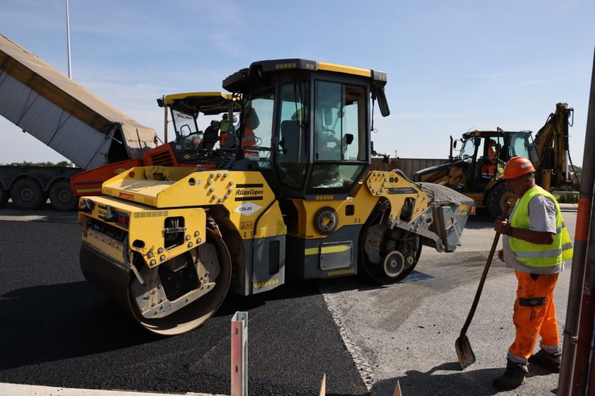 Robotnicy pracujący na wiadukcie, układają ostatnią warstwę nawierzchni