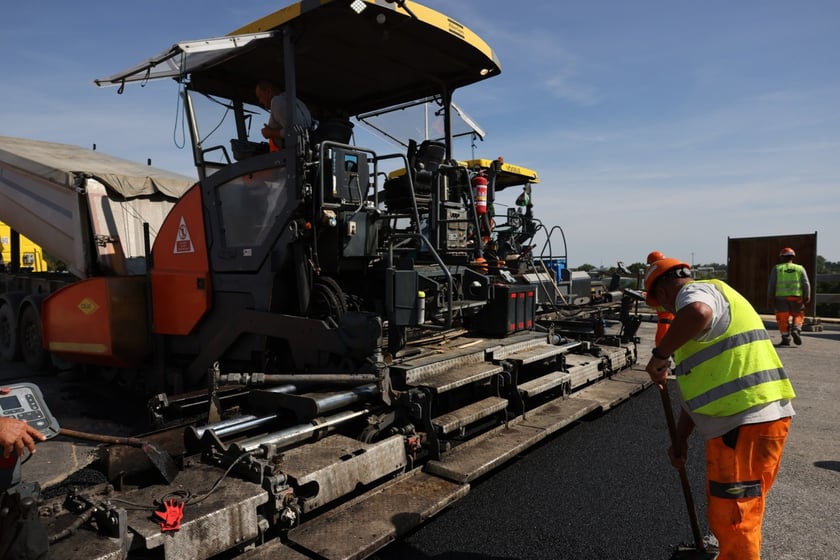 Robotnicy pracujący na wiadukcie, układają ostatnią warstwę nawierzchni