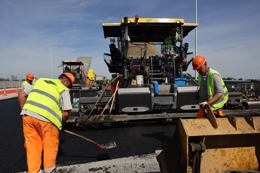 Robotnicy pracujący na wiadukcie, układają ostatnią warstwę nawierzchni