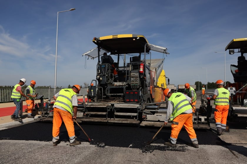 Robotnicy pracujący na wiadukcie, układają ostatnią warstwę nawierzchni