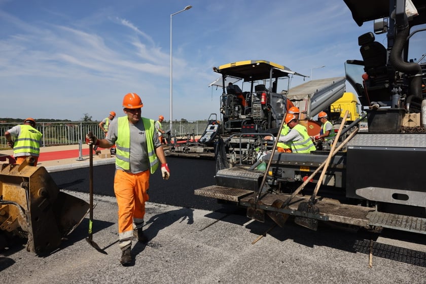 Robotnicy pracujący na wiadukcie, układają ostatnią warstwę nawierzchni