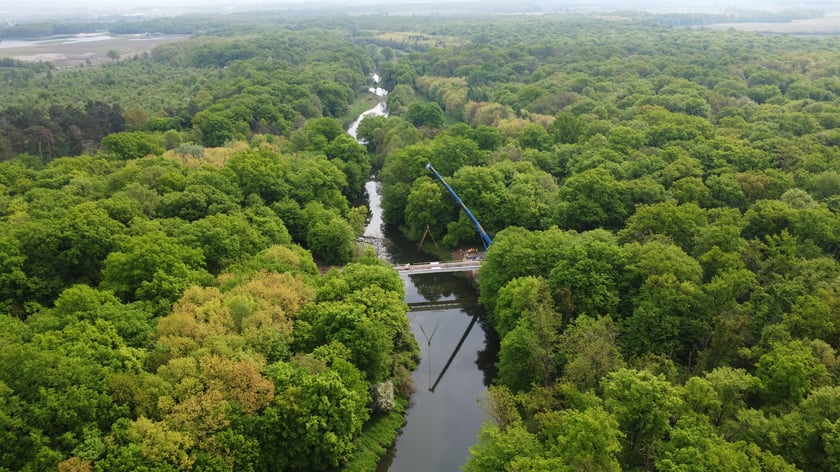 Budowa kładki nad Widawą. Montaż konstrukcji, kt&oacute;ra połączyła brzegi rzeki. Zdjęcie z 24 kwietnia 2025 r.