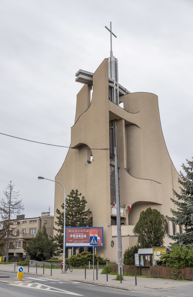 Kości&oacute;ł pw. Tr&oacute;jcy Świętej powstał na przebudowie budynku mieszkalnego. Starania o wzniesienie świątyni trwały kilkanaście lat. Projekt zrealizowano w latach 1979-1987. Bryła budowli jest zwarta, o zaokrąglonych narożach i tr&oacute;jkątnych aneksach. Dwie ściany zasłaniające dach wznoszą się łukami ku g&oacute;rze, tworząc w miejscu styku wieżę z przeszkleniem, spiętą konstrukcją żelbetową. W dolnej partii elewacji są arkadowe wnęki. W budowli mieści się kości&oacute;ł g&oacute;rny i dolny, zakrystia, pomieszczenia pomocnicze i księgarnia.