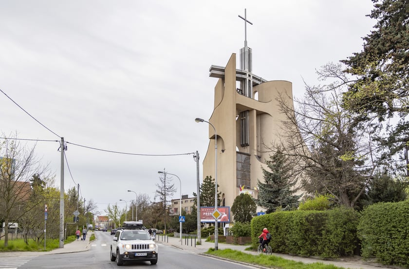 Kości&oacute;ł pw. Tr&oacute;jcy Świętej powstał na przebudowie budynku mieszkalnego. Starania o wzniesienie świątyni trwały kilkanaście lat. Projekt zrealizowano w latach 1979-1987. Bryła budowli jest zwarta, o zaokrąglonych narożach i tr&oacute;jkątnych aneksach. Dwie ściany zasłaniające dach wznoszą się łukami ku g&oacute;rze, tworząc w miejscu styku wieżę z przeszkleniem, spiętą konstrukcją żelbetową. W dolnej partii elewacji są arkadowe wnęki. W budowli mieści się kości&oacute;ł g&oacute;rny i dolny, zakrystia, pomieszczenia pomocnicze i księgarnia.