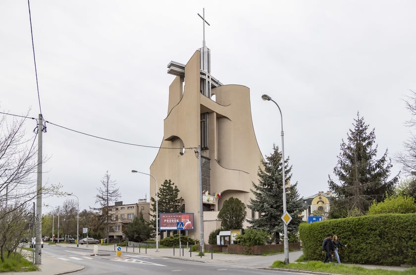 Kości&oacute;ł pw. Tr&oacute;jcy Świętej powstał na przebudowie budynku mieszkalnego. Starania o wzniesienie świątyni trwały kilkanaście lat. Projekt zrealizowano w latach 1979-1987. Bryła budowli jest zwarta, o zaokrąglonych narożach i tr&oacute;jkątnych aneksach. Dwie ściany zasłaniające dach wznoszą się łukami ku g&oacute;rze, tworząc w miejscu styku wieżę z przeszkleniem, spiętą konstrukcją żelbetową. W dolnej partii elewacji są arkadowe wnęki. W budowli mieści się kości&oacute;ł g&oacute;rny i dolny, zakrystia, pomieszczenia pomocnicze i księgarnia.