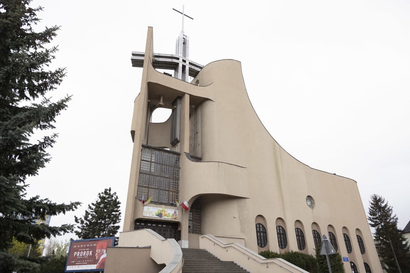 Kości&oacute;ł pw. Tr&oacute;jcy Świętej powstał na przebudowie budynku mieszkalnego. Starania o wzniesienie świątyni trwały kilkanaście lat. Projekt zrealizowano w latach 1979-1987. Bryła budowli jest zwarta, o zaokrąglonych narożach i tr&oacute;jkątnych aneksach. Dwie ściany zasłaniające dach wznoszą się łukami ku g&oacute;rze, tworząc w miejscu styku wieżę z przeszkleniem, spiętą konstrukcją żelbetową. W dolnej partii elewacji są arkadowe wnęki. W budowli mieści się kości&oacute;ł g&oacute;rny i dolny, zakrystia, pomieszczenia pomocnicze i księgarnia.