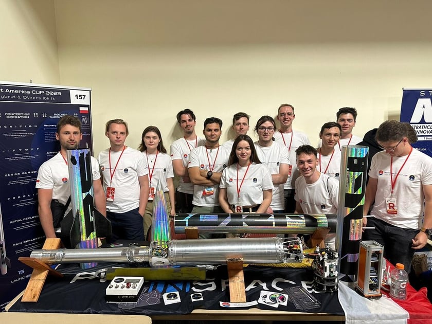 Prezentacja rakiety na stanowisku zespołu, dzień konferencyjny zawod&oacute;w Spaceport America Cup.&nbsp;Od lewej:&nbsp;Jakub Maszkowski, Krzysztof Gozdek, Adrianna Łukaszyk, Michał Kos, Adam Domachowski, Seweryn Pola, Liliya Sizhuk,Sebastian Kr&oacute;l, Jakub Gienieczko, Jakub Siuda, Michał Kowalski, Krzysztof Gozdek, Jakub Perliński, Jakub Zatoń
