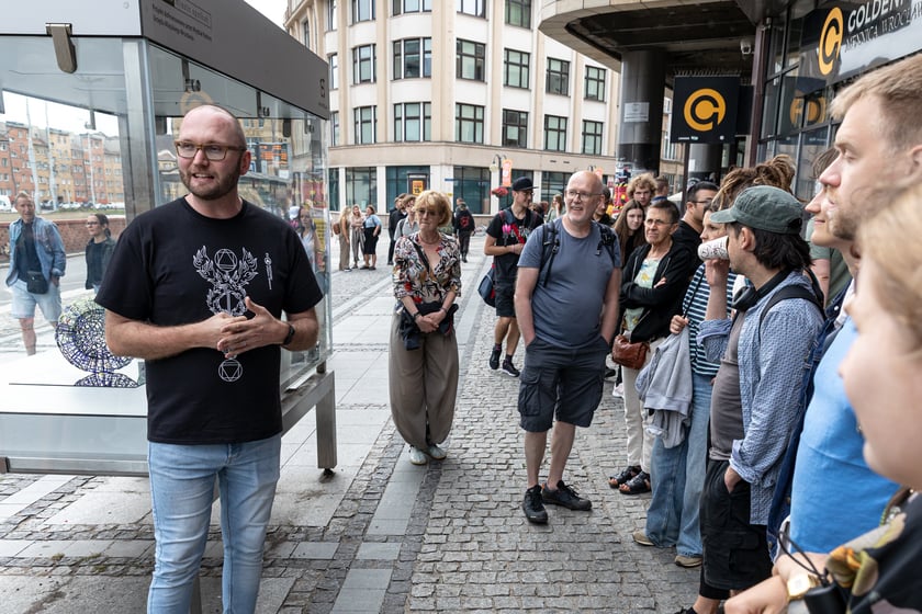 Powiększ obraz: Ludzie obserwujący gabloty na ul. Oławskiej