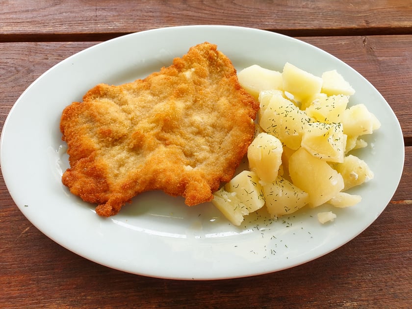 Dzień Kotleta Schabowego. Na zdjęciu kotlet schabowy z ziemniakami na talerzu.