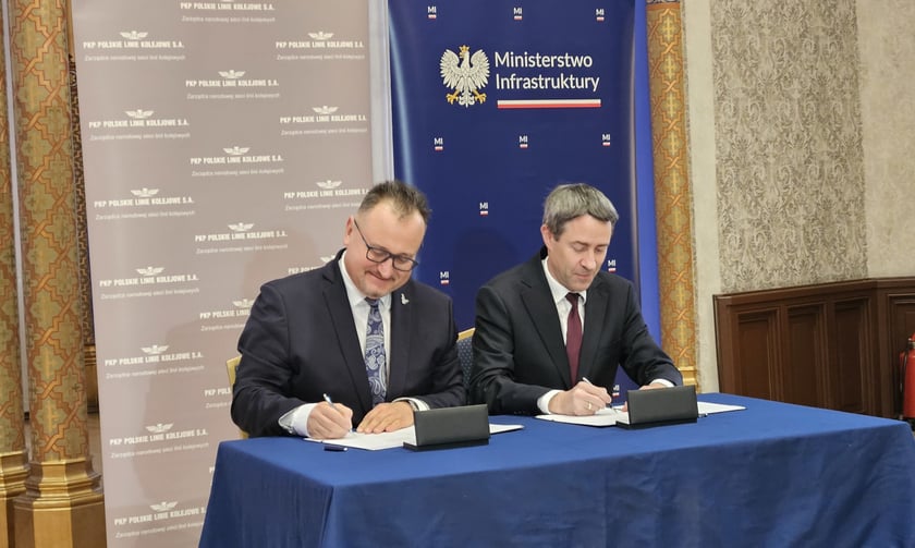 Piotr Rachwalski, członek zarządu CPK ds. kolei (po lewej) i Piotr Wyborski, prezes PKP PLK (po prawej) podpisują porozumienie.