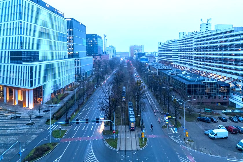 Widok z lotu ptaka na dwujezdniową ulicę, z torowiskiem tramwajowym po środku i budynki stojące przy niej. Wyremontowany fragment ul. Powstańców Śląskich.