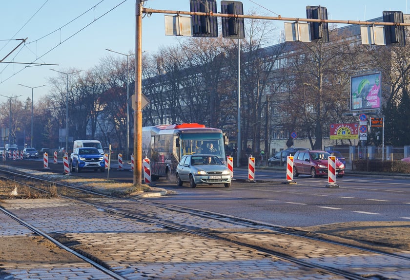 Jezdnia ze sfrezowanym asfaltem na jednym pasie i auta jadące po drugim - remontowany fragment ul. Powstańców Śląskich.