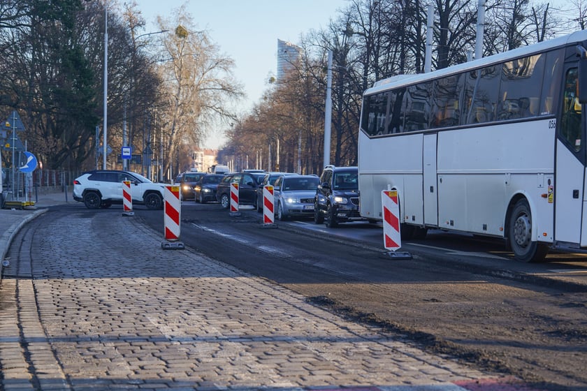 Jezdnia ze sfrezowanym asfaltem na jednym pasie i auta jadące po drugim - remontowany fragment ul. Powstańców Śląskich.
