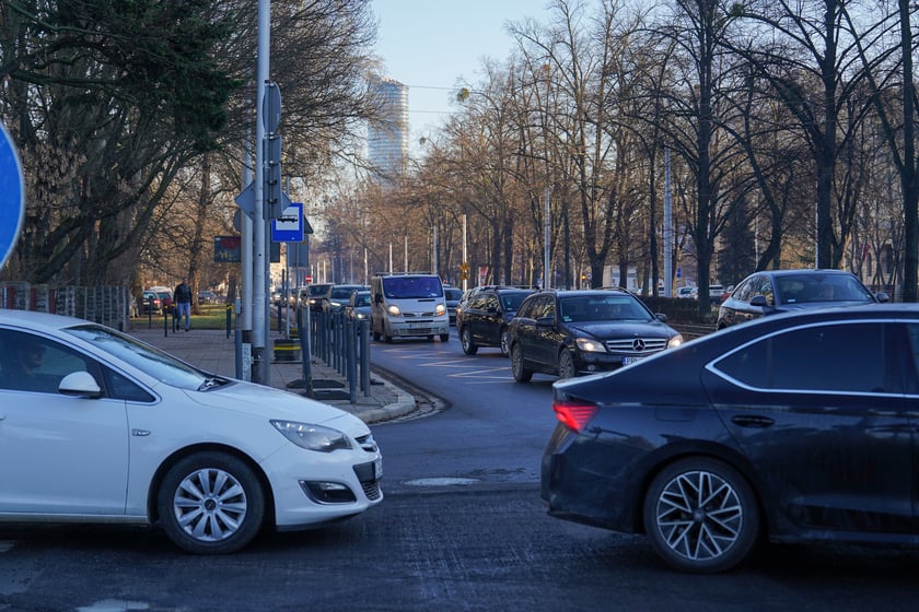 Jezdnia ze sfrezowanym asfaltem na jednym pasie i auta jadące po drugim - remontowany fragment ul. Powstańców Śląskich.