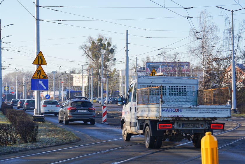 Jezdnia ze sfrezowanym asfaltem na jednym pasie i auta jadące po drugim - remontowany fragment ul. Powstańców Śląskich.