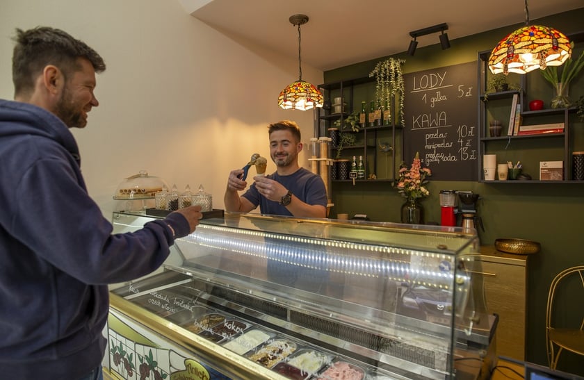 - Polecam malinowe, wegańskie lody typu sorbet i wiele innych smaków i rodzajów lodów - mówi Paweł Jakubowski, właściciel lodziarni Cybulskiego 10 i nakłada gałkę lodów o smaku prażonych orzechów włoskich.