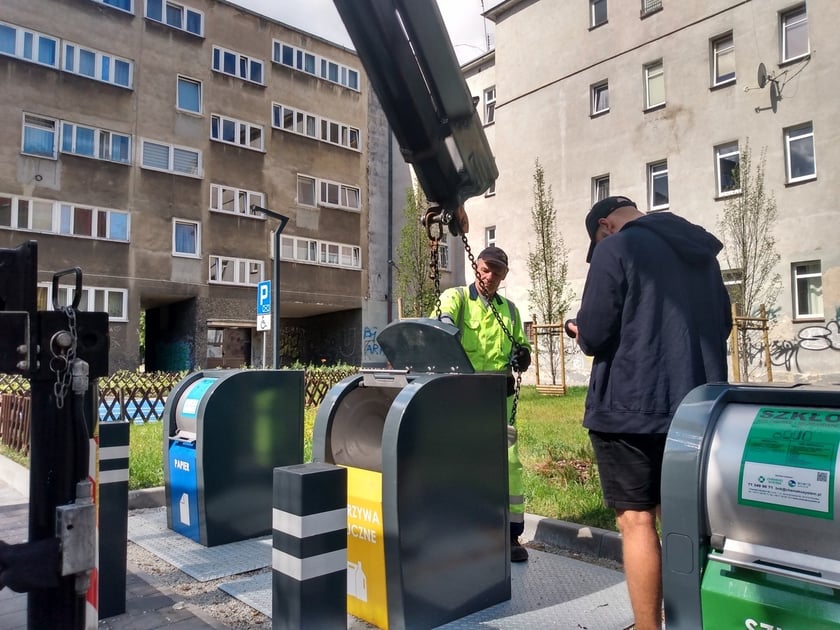 Wyciąganie podziemnego pojemnika na odpady na podwórku w okolicach pl. Nowy Targ i pl. Nankiera