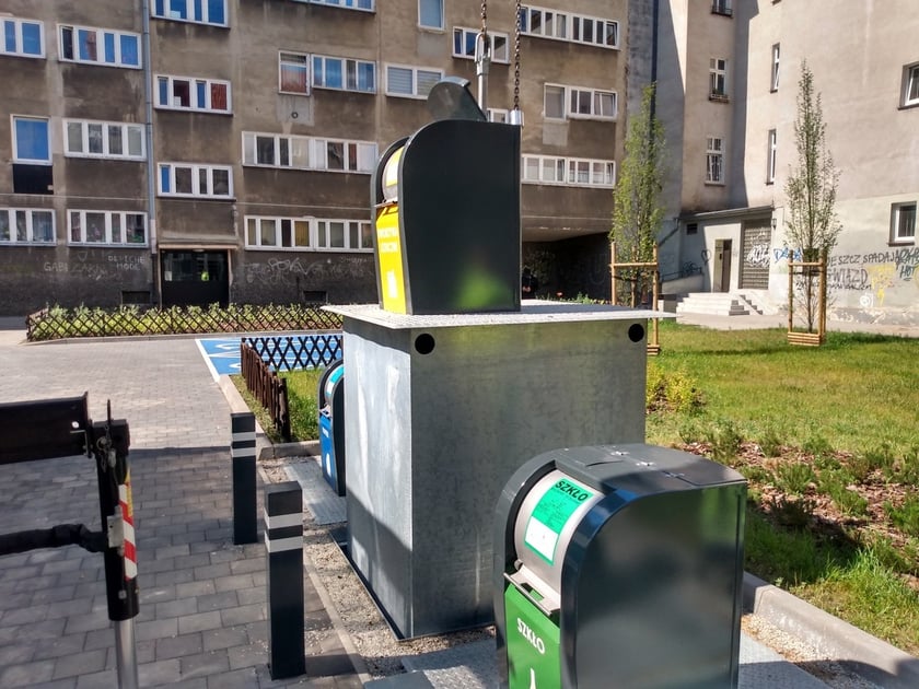 Wyciąganie podziemnego pojemnika na odpady na podwórku w okolicach pl. Nowy Targ i pl. Nankiera