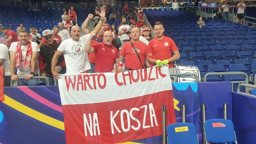 Kibice reprezentacji Polski, wśród nich Szoku podczas Eurobasketu 2022, z flagą - Warto chodzić na kosza