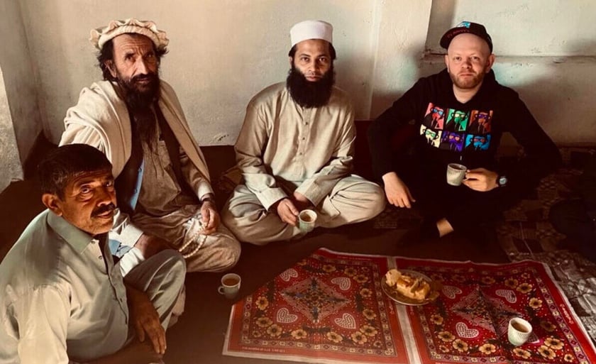 Na zdjęciu Andrzej Gliniak siedzi na dywanie i pije herbatę w towarzystwie Pakistańczyków w Peszawarze, jednym z najniebezpieczniejszych miast Pakistanu, tuż przy granicy z Afganistanem. Siedzący najbliżej mężczyzna ma ksywkę ?Talib?.