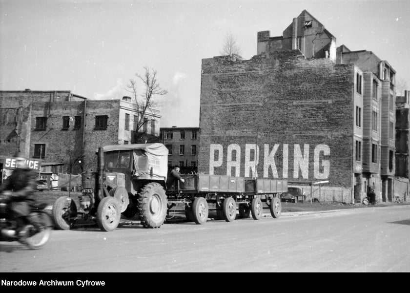 Wrocław w latach 60. XX w. Ciągnik Ursus C-45 z przyczepami przy parkingu. Widoczne odbudowywane kamienice.	1962