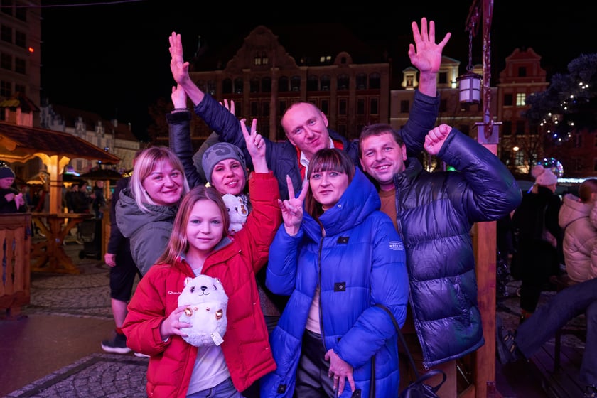 Sylwester 2022 na wrocławskim Rynku. Na zdjęciu widać ludzi, którzy w ostatnią noc 2022 roku bawili się na Jarmarku Bożonarodzeniowym we Wrocławiu