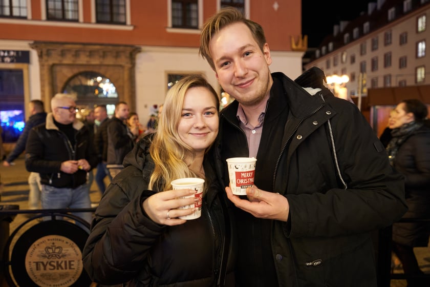 Sylwester 2022 na wrocławskim Rynku. Na zdjęciu widać ludzi, którzy w ostatnią noc 2022 roku bawili się na Jarmarku Bożonarodzeniowym we Wrocławiu