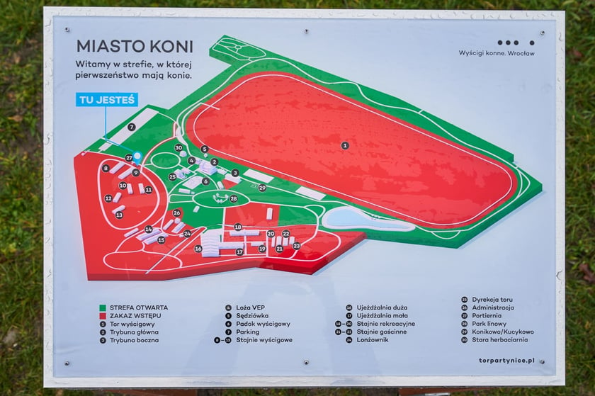 Tablica informacyjna o wydzielonych na terenie Wrocławskich Tor&oacute;w Wyścigowych - Partynice strefach dla ludzi i koni (zielona) i tylko dla koni (czerwona)