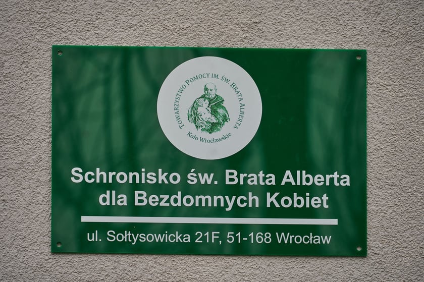 Tablica informacyjna, napis: Achronisko św. Brata Alberta dla Bezdomnych Kobiet ul. Sołtysowicka 21F