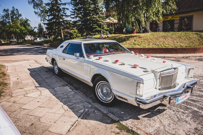 Lincoln Continental z 1977 roku
Zabytkowy 6-ścio osobowy amerykański krążownik z segmentu Luxury Car.&nbsp;&minus;&nbsp;Poczuj moc 7,5 litrowej V8 i popłyń Lincolnem do ślubu, samoch&oacute;d dosłownie płynie po drogach. Autem tej marki poruszał się m.in. gł&oacute;wny bohater filmu American Gangster, Frank Lucas (Denzel Washington).
Wynajem samochodu obejmuje przejazd wraz z elegancko ubranym, doświadczonym kierowcą:

odebranie Pana Młodego,
dojazd z Panem Młodym do Panny Młodej,
przewiezienie do kościoła lub Urzędu Stanu Cywilnego,
przejazd na salę weselną,
ewentualny udział w sesji zdjęciowej w dniu ślubu,
przystrojenie samochodu sztucznymi kwiatami oraz tablice rejestracyjne Młoda Para / Nowożeńcy.

Koszt wynajmu uzgadniany jest indywidualnie z klientem. Obsługa obejmuje całe wojew&oacute;dztwo dolnośląskie oraz częściowo lubuskie, wielkopolskie i opolskie.
Telefon kontaktowy:&nbsp;722 211 144.&nbsp;Szczeg&oacute;ły na stronie internetowej właściciela.