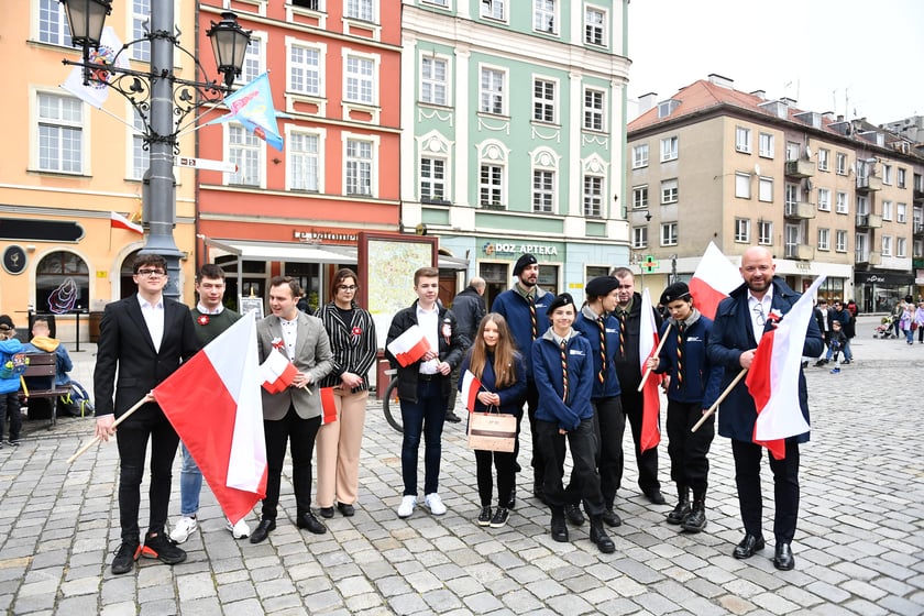 Prezydent Wrocławia Jacek Sutryk rozdaje flagi mieszkańcom i turystom.