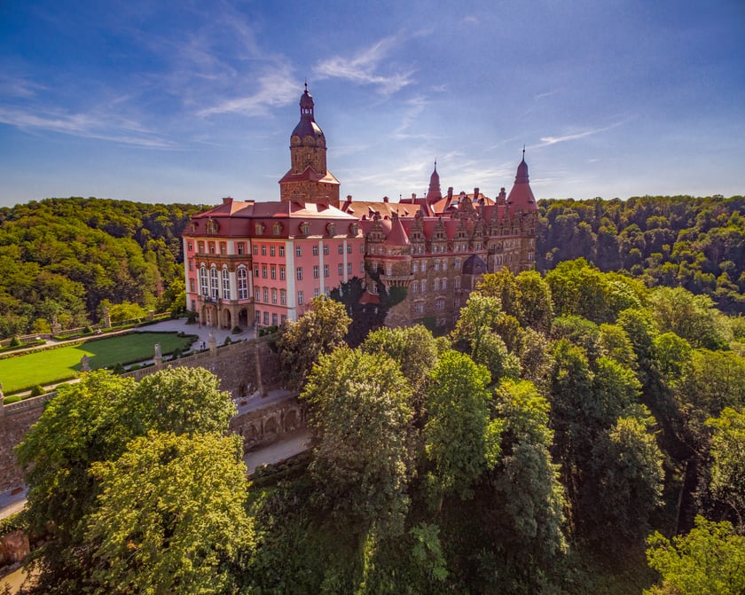 Zamek Książ
Zamek Książ to jeden z najpiękniej położonych zamk&oacute;w w Europie &ndash; wznosi się na cyplu skalnym i otoczony jest lasami Książańskiego Parku Krajobrazowego. Przepych, barokowe wnętrza, książęce apartamenty oraz zapierające dech widoki to idealna propozycja na miejsce organizacji ślubu i wesela.
&ndash; Marzysz o bajecznym weselu w zachwycającym miejscu? Pragniesz, żeby ten wyjątkowy dzień był niezapomniany? W Zamku Książ sprostamy oczekiwaniom nawet najbardziej wymagającej Panny Młodej. Specjalnie dla Was udostępnimy nasze książęce przestrzenie i luksusowe pokoje hotelowe, sprowadzimy utalentowanych floryst&oacute;w, zapewnimy weselne atrakcje, a wsp&oacute;łpracujące z nami restauracje przygotują wymyślne propozycje menu. Zrealizujemy Waszą wsp&oacute;lną wizję książęcego ślubu w jednym z najpiękniejszych miejsc na ziemi &ndash; czytamy na stronie zamku.
Przyjęcie weselne można zorganizować na jednej z dw&oacute;ch sal &ndash; Sali Balowej (do 150 os&oacute;b) lub Sali Krzywej (do 50 os&oacute;b). Dodatkową atrakcją dla Państwa Młodych jest podjazd bryczką pod zamek w asyście rycerskiej czy pokaz walk rycerzy średniowiecznych o rękę damy swojego serca.&nbsp;

Adres:&nbsp;Piast&oacute;w Śląskich 1, Wałbrzych

Szczeg&oacute;ły dotyczące oferty można przeczytać na stronie Zamku Książ.
