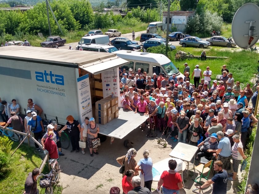 Ludzie czekający na paczki żywnościowe w Iziumie