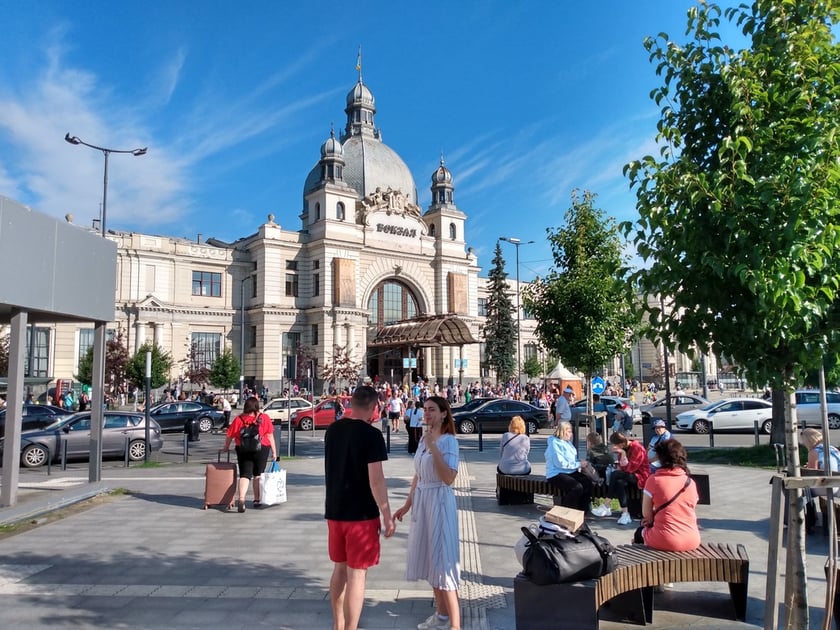 Lw&oacute;w. Podr&oacute;żni przed dworcem kolejowym