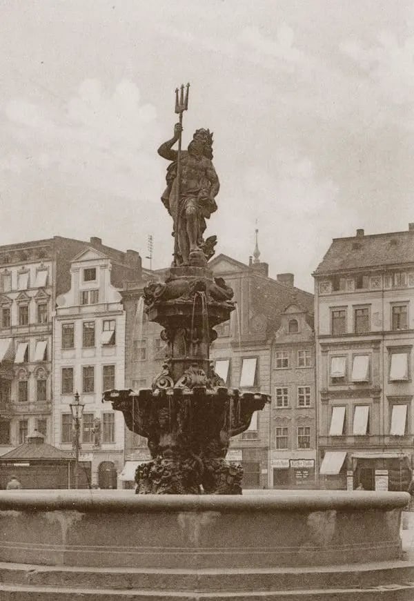 Fontanna Neptuna&nbsp;
pl. Nowy Targ
Barokowa Fontanna Neptuna powstała w tym miejscu na zlecenie rady miejskiej w 1732 r. Zbudował ją z piaskowca wrocławski kamieniarz Johann Adam Karinger wsp&oacute;lnie z Johannem Baptistą Lembergergiem, a za rzeźby odpowiadał Johann Jakob Bauer.
Neptun, b&oacute;g w&oacute;d, odpowiednik boga morza Posejdona, stanął na Nowym Targu m.in. w nawiązaniu do prowadzonego przez wrocławskich kupc&oacute;w zamorskiego handlu. Nie od razu jednak podbił serca mieszkańc&oacute;w. Po pierwsze, co niekt&oacute;rych kłuła w oczy jego golizna, po drugie kojarzył się wrocławianom z postacią diabła. Potocznie nazywano go Gabelj&uuml;rgen, czyli Jurkiem z widłami.
Do niedawna myślano, że wspomniany barokowy posąg boga w&oacute;d, podobnie jak cała fontanna, został zniszczony w 1945 roku podczas wojny. Jak wykazał niedawno Tomasz Sielicki z Wrocławia, podczas generalnego remontu fontanny na Nowym Targu w 1874 roku powstała druga rzeźba Neptuna autorstwa Alberta Rachnera, tw&oacute;rcy popiersia Linneusza w Ogrodzie Botanicznym. I to właśnie ta nowa została zniszczona podczas drugiej wojny światowej.
Pierwszy, oryginalny Neptun trafił na prywatną posesję byłego radnego miejskiego, porucznika Carla M&uuml;llera w Wielowsi koło Sycowa. I po latach został tam odnaleziony przez wspomnianego Tomasza Sielickiego.
&nbsp;