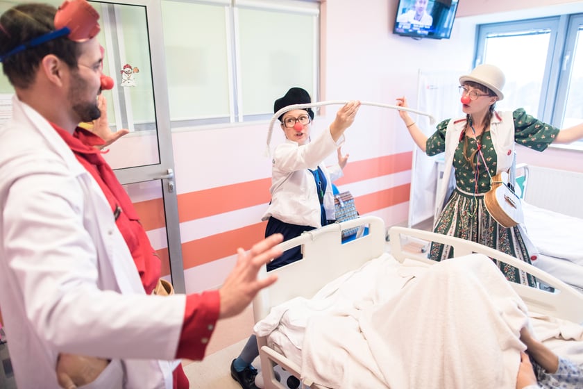 Klowni medyczni Z Fundacji Czerwone Noski podczas pracy, ktora polega na&nbsp;rozweselaniu dzieci w szpitalu