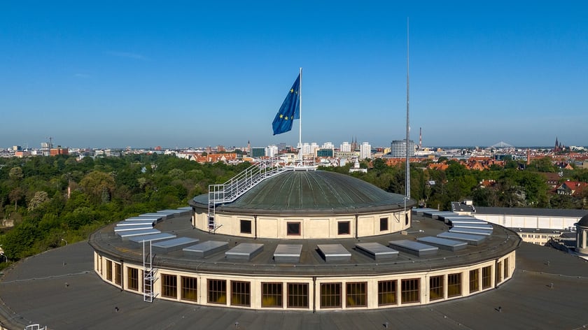 Hala Stulecia. Unijna flaga na szczycie Hali Stulecia, w tle panorama Wrocławia