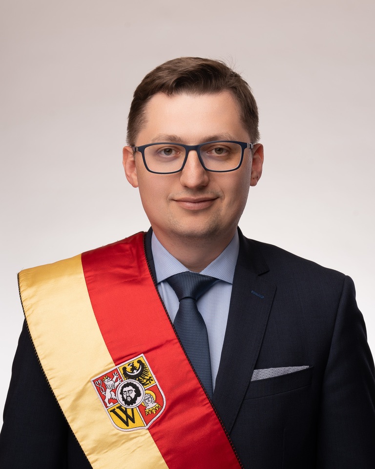 Rocznik 1989. Absolwent Wydziału Prawa Administracji i Ekonomii Uniwersytetu Wrocławskiego. Ukończył także studia MBA w Warszawie oraz na Uniwersytecie Przyrodniczym we Wrocławiu w zakresie wyceny nieruchomości. Od 15 lat przewodniczący rady osiedla Nowy Dw&oacute;r. Członek Wrocławskiego Szkolnego Związku Sportowego i Akcji Katolickiej. Pracuje w Polskiej Sp&oacute;łce Gazownictwa.
Komisje: statutowa | edukacji i młodzieży
KLUB RADNYCH PRAWA I SPRAWIEDLIWOŚCI