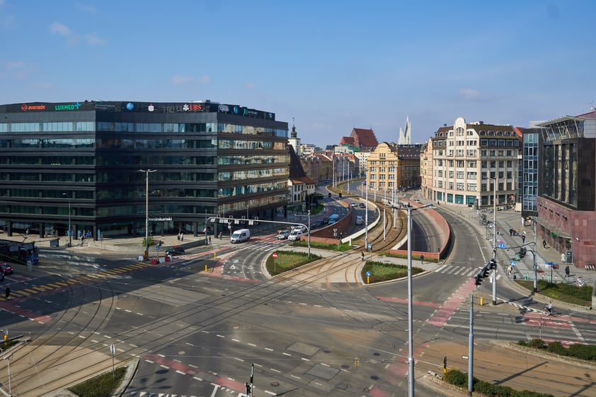c) w nazwach obiekt&oacute;w przestrzeni publicznej wprowadzenie pisowni wielką literą stojącego na początku wyrazu aleja, brama, bulwar, osiedle, plac, park, kopiec, kości&oacute;ł, klasztor, pałac, willa, zamek, most, molo, pomnik, cmentarz (przy utrzymaniu pisowni małą literą wyrazu ulica), np. ulica Piłsudskiego, Aleja Wiśniowa, Plac Grunwaldzki, Plac Dominikański, Brama Warszawska, Park Szczytnicki, Kości&oacute;ł Mariacki, Pałac Staszica, Zamek Książ, Most Zwierzyniecki, Pomnik Ofiar Getta, Cmentarz Grabiszyński;
Na zdjęciu plac Dominikański.