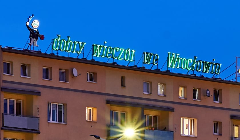 Wieczorny widok na budynek z neonem&nbsp;&bdquo;dobry wiecz&oacute;r we Wrocławiu&rdquo;, maj 2023