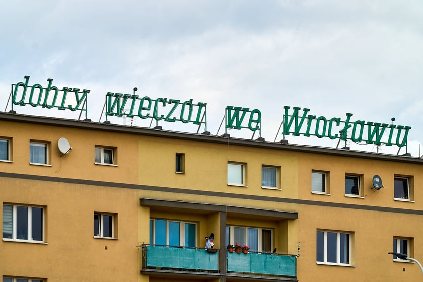 Zdejmowanie rurek z napisu i pana neonu "dobry wieczór we Wrocławiu"