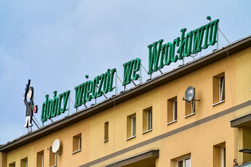 Zdejmowanie rurek z napisu i pana neonu "dobry wieczór we Wrocławiu"