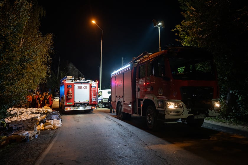 Kobiety i mężczyźni układają worki z piaskiem na Marszowicach w nocy z 17 na 18 września 2024 roku