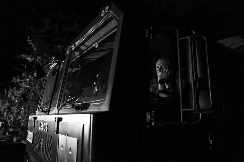 Kobiety i mężczyźni układają worki z piaskiem na Marszowicach w nocy z 17 na 18 września 2024 roku