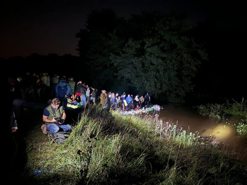 Kobiety i mężczyźni podczas akcji  na wale Janówek - Pracze. Trwa jego uszczelnianie