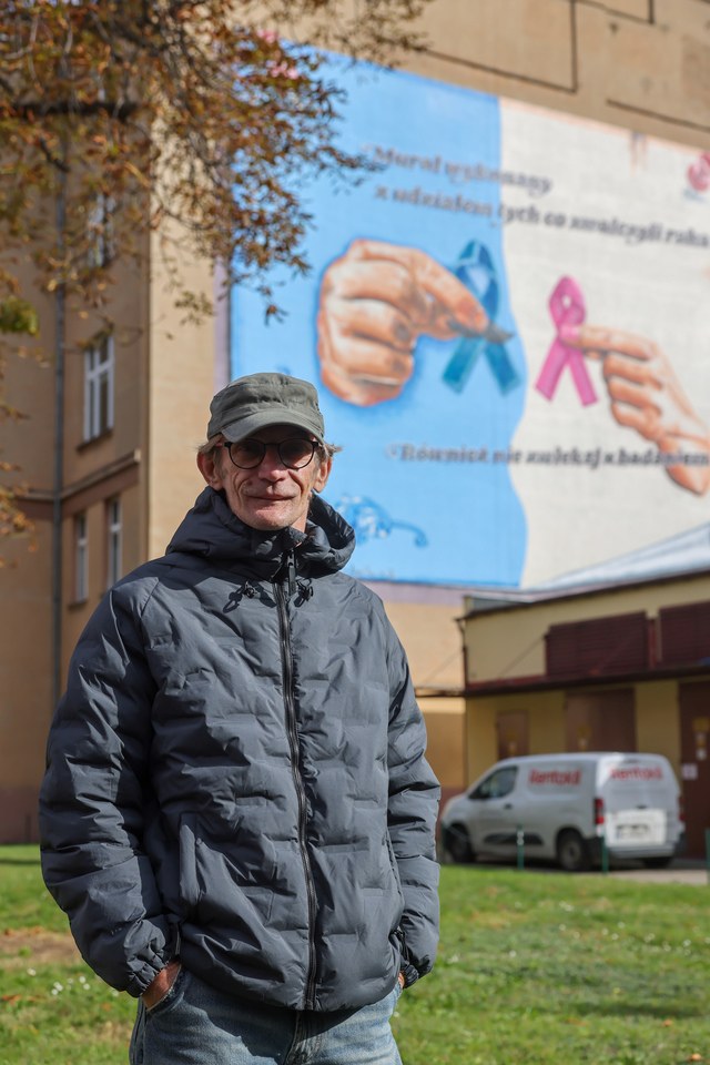Wojtek Miszewski na tle muralu